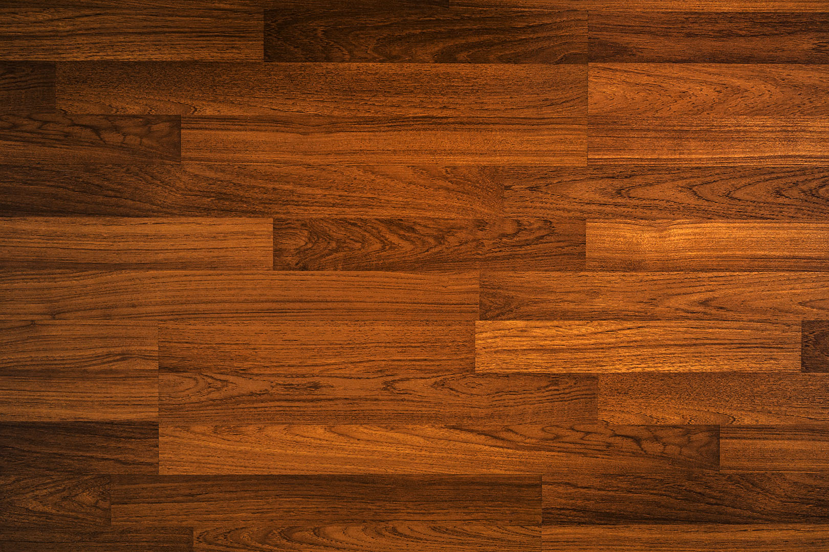 Nahaufnahme eines dunkelbraunen Laminatbodens mit sichtbarer Holzstruktur.