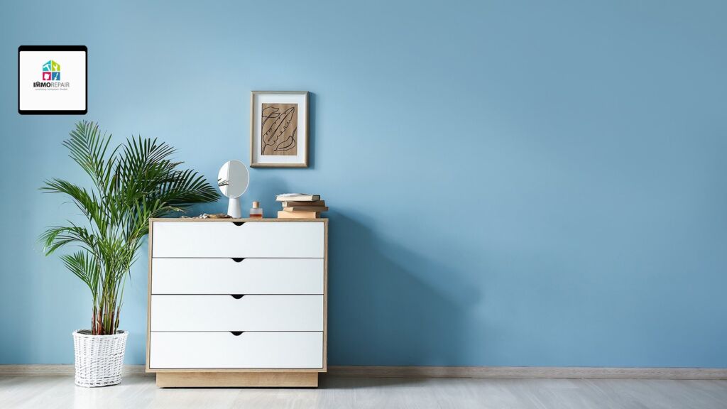 Hellblau gestrichene Wand mit weißer Kommode, Zimmerpalme und gerahmtem Bild