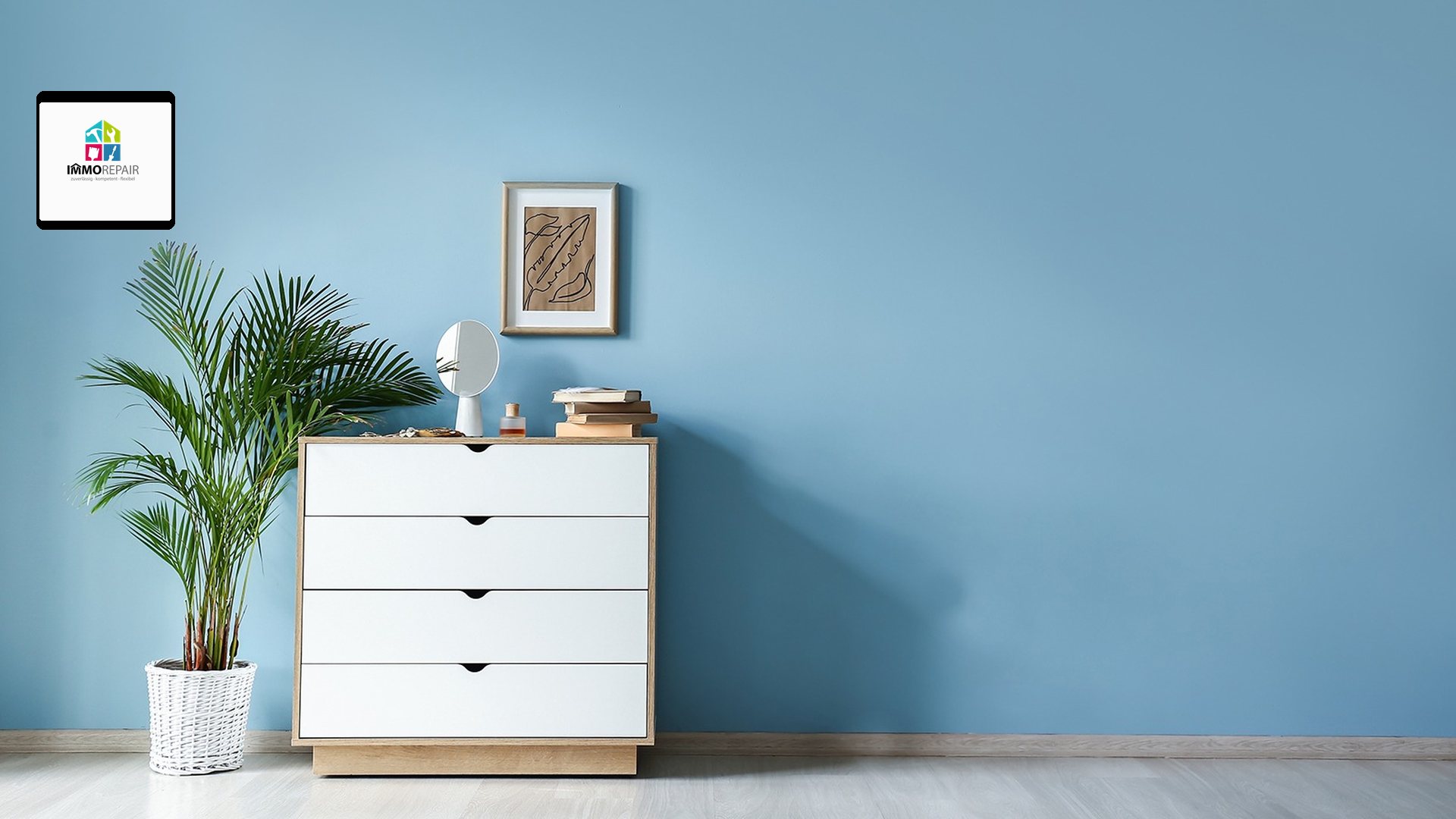 Hellblau gestrichene Wand mit weißer Kommode, Zimmerpalme und gerahmtem Bild